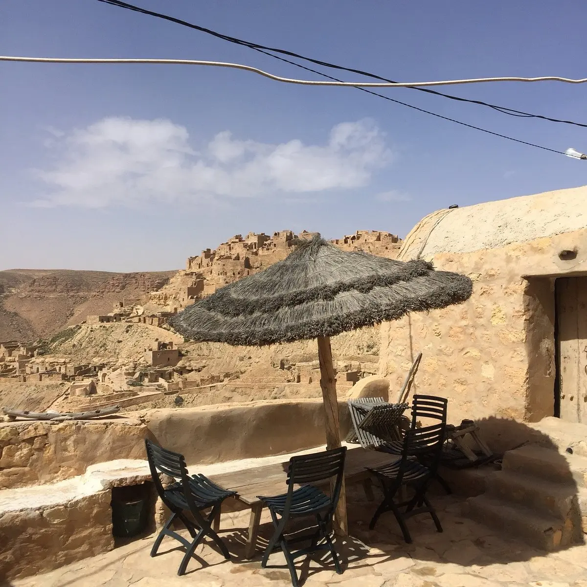Terrasse du restaurant Kenza avec vue panoramique sur le village berbère de Chenini et les collines arides du sud tunisien.